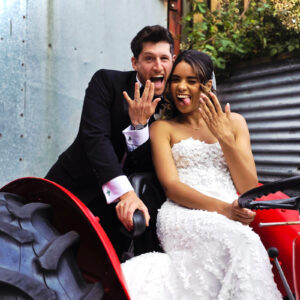 Bride and groom laughing and showing their wedding rings at a UK wedding