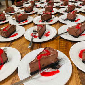 Vegan chocolate cheesecake slices with raspberry coulis plated up for a UK wedding by Vegan Junkies