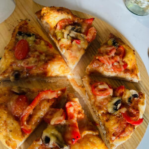 Vegan pizza slices on a wooden board served at a UK wedding by Vegan Junkies