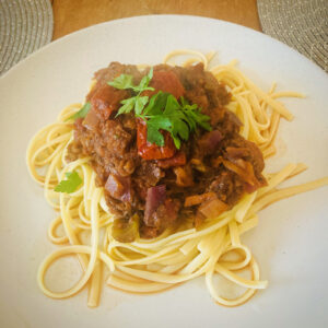 Vegan spaghetti bolognese garnished with fresh parsley served at a UK wedding by Vegan Junkies